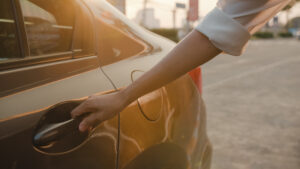 Woman's hand reaching for car door handle