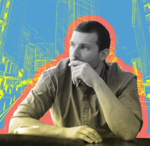 Man sitting at a desk on blue background.